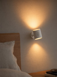 Loft wireless wall sconce above bedroom nightstand, warm glow